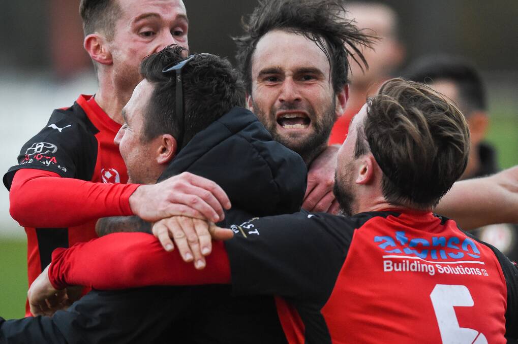 MAGIC MOMENT: Elliot Jones is swamped by his players after a crucial win against Nunawading City at home last year to ensure Murray United remained in NPL 2 for another season. Picture: MARK JESSER