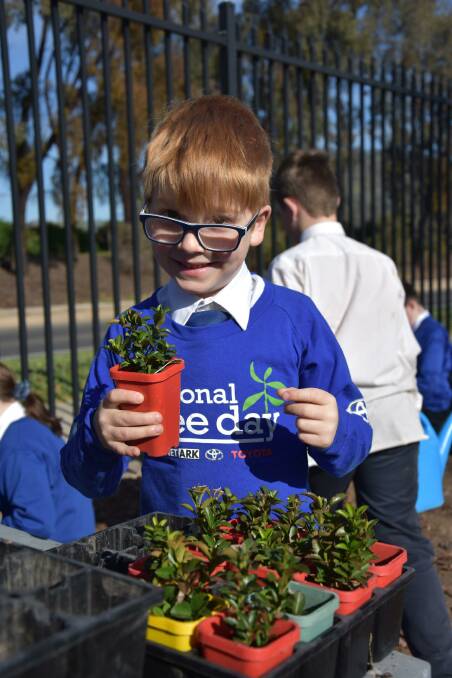 ALL SMILES: Victory Lutheran College foundation student Connor Maloy prepares to plant a seedling for the school's Tree Day. A range of year levels were involved in the event within the school grounds.