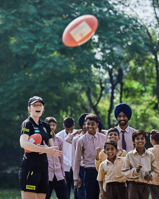 HAPPY DAYS: Madison Murdoch was all smiles during this visit to an Indian school as students took a liking to Australian rules football. Picture: ANTHONY JUCHNEVICIUS