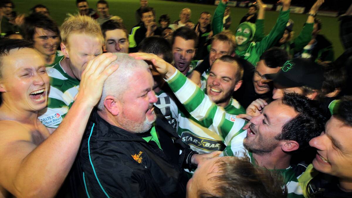 BACK IN CHARGE: Scott Kidd is swamped by his players after taking Albury United to victory in the 2012 AWFA cup final. Kidd will return to the top job next season.