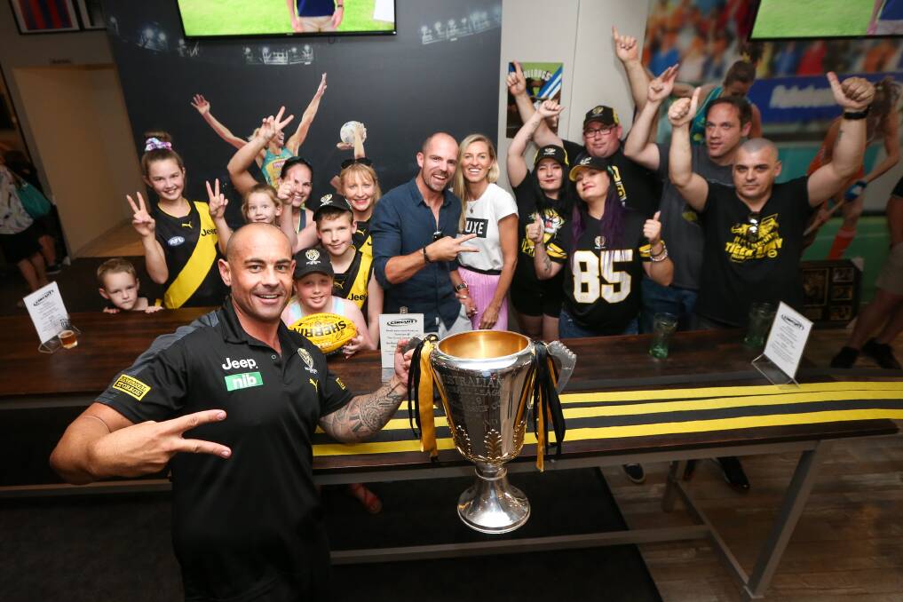 FANS GALORE: Richmond's Simon Bryson shows off the 2019 AFL premiership cup to Tigers supporters at Albury's Circuit Sports Cafe on Wednesday during the club's regional tour. Picture: JAMES WILTSHIRE