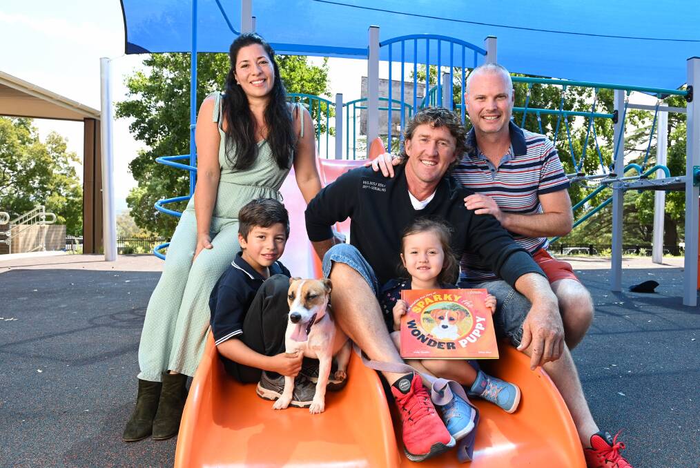 FAMILY TIES: Carolina, Logan, 5, Sparky, Michael and Summer Wild, 3, with a new children's book based on their dog's bushfires survival. Pictures: MARK JESSER