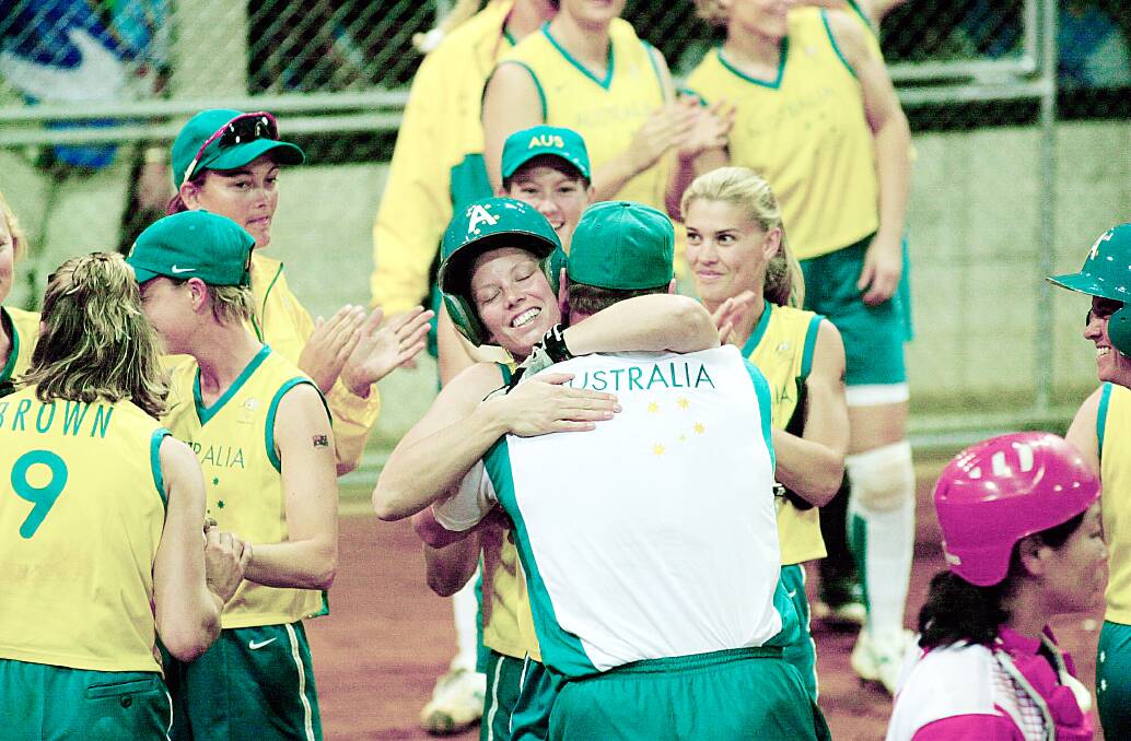 TOP TOURNAMENT: Albury softballer Peta Edebone is swamped at home plate after hitting the winner against China to guarantee Australia the bronze medal.