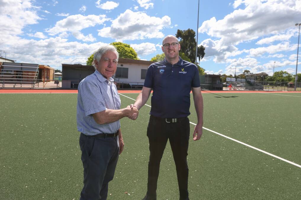 Bert Eastoe and Hockey ACT chief executive Rob Sheekey shake hands to mark with the Border association's affiliation with the territory body. 
