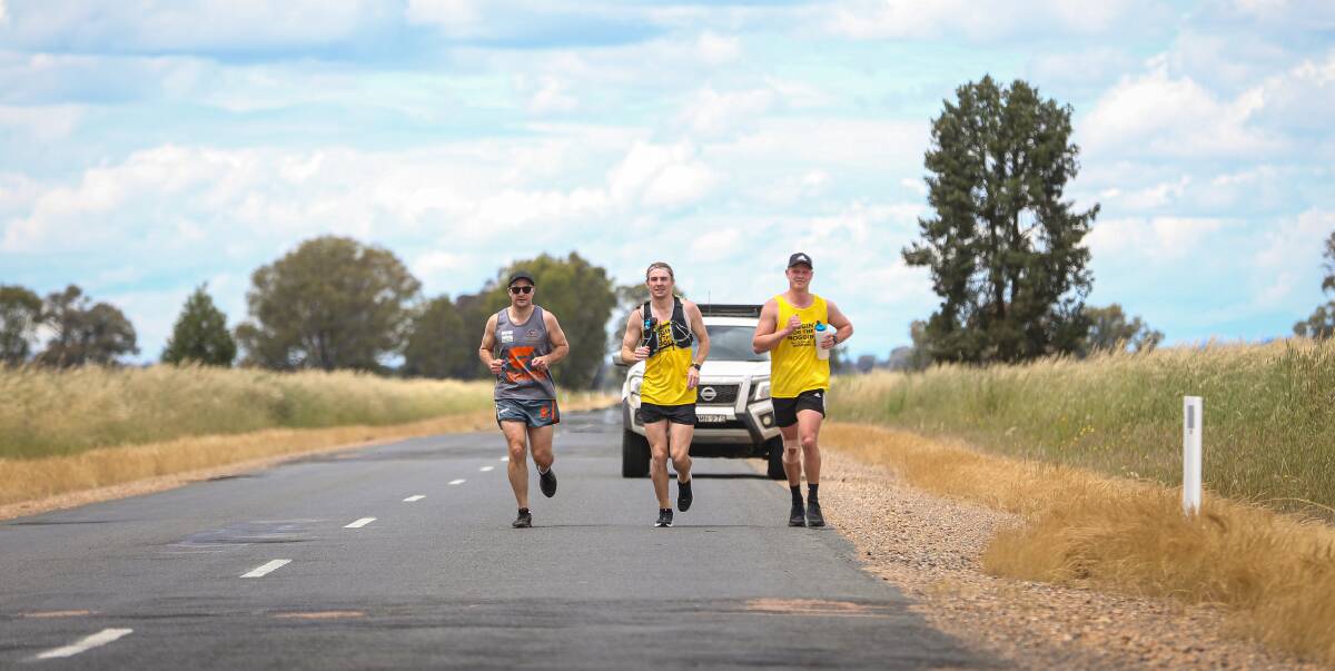 GIANT RUN: Rand-Walbundrie-Walla footballer Matt Robertson (centre), with Lucas Mellier and Beau Shoard, closing in on Walbundrie after running 55 kilometres from Thurgoona for mental health on Saturday. Picture: JAMES WILTSHIRE