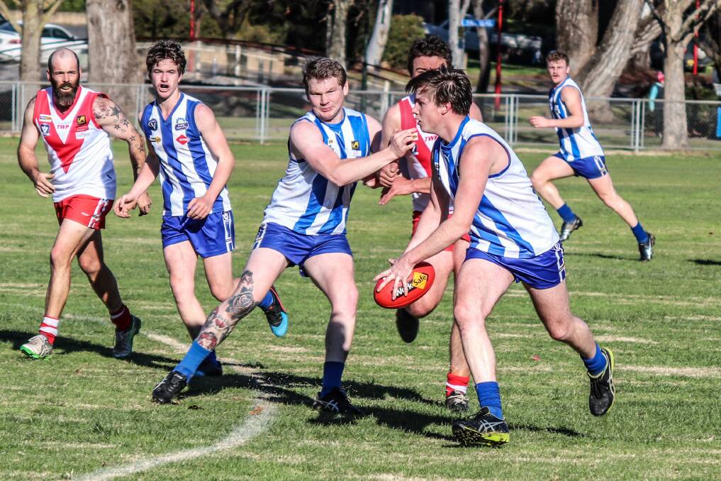 HELPING OUT: Hunter Clayton shepherds a Federal player as Sam Crozier gets away with the ball during the Roos' massive win against the Swans. Picture: WENDY LAVIS