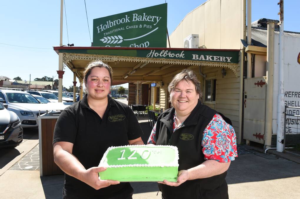 FLASHBACK: Brielle Perkins and Vicki Fulford mark Holbrook Bakery's 120th birthday last year. The 121st hasn't been as smooth with COVID-19 restrictions in place.
