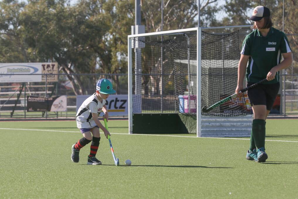 ONE TO WATCH: Oliver Clarke, 6, works on his skills with Brodie Hamilton during the final Tiger Moth come and try session at Albury Hockey Centre. Picture: TARA TREWHELLA