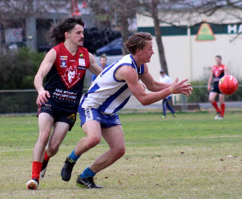 THINK QUICK: Tumbarumba's James Munday receives a handball as pressure is applied by his Corryong opponent at Tumbarumba Recreation Reserve on Saturday. Pictures: DEB HARRAP