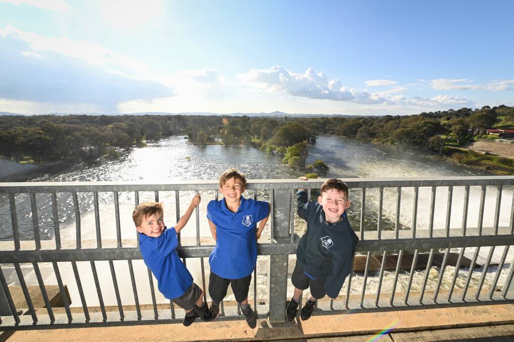 WHAT A SIGHT: Thurgoona Public School students Theodore Owen, 5, Hamish Owen 8, and Ethan Burrell, 8, enjoy the water release at the Hume Dam wall on Monday. Picture: MARK JESSER