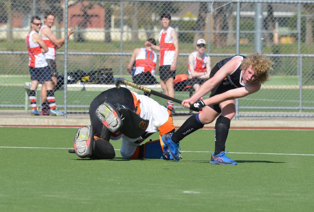 HIT THE DECK: Grey goalkeeper Andrew Paterson tries desperately to block the shot of Black's Campbell Cull during the premier men's semi-finals. Picture: NARELLE HAMILTON 