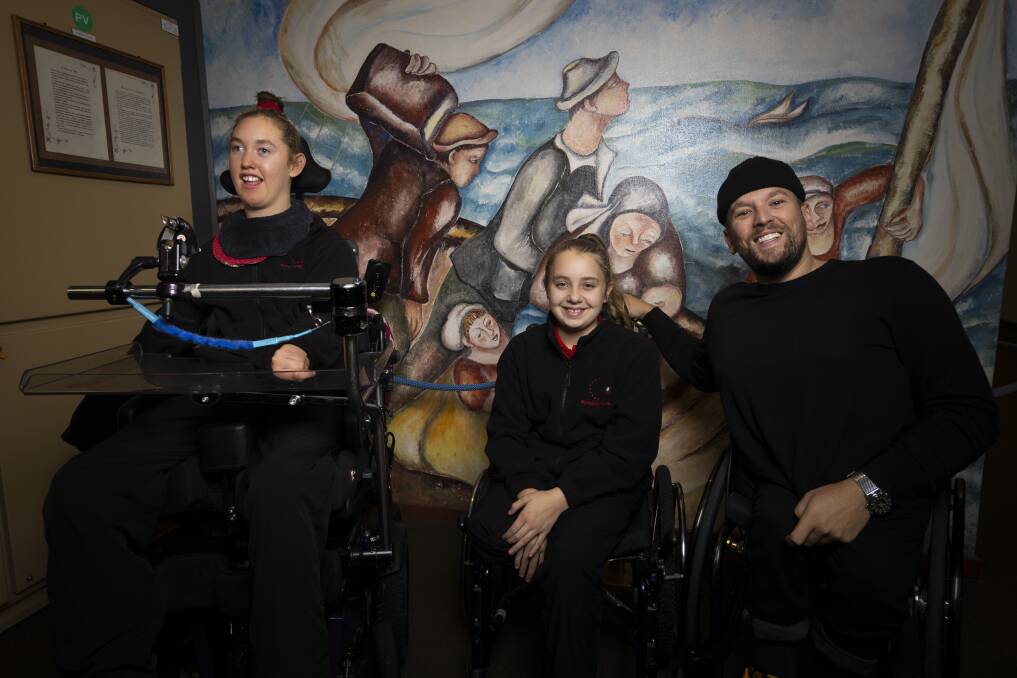 ALL SMILES: Wheelchair tennis and basketball Paralympic champion and Australian of the Year Dylan Alcott catches up with Myrtleford P-12 College students Meg Casley, 14, and Taleah Elkington, 12, during his visit to Alpine Shire on Thursday. Pictures: ASH SMITH