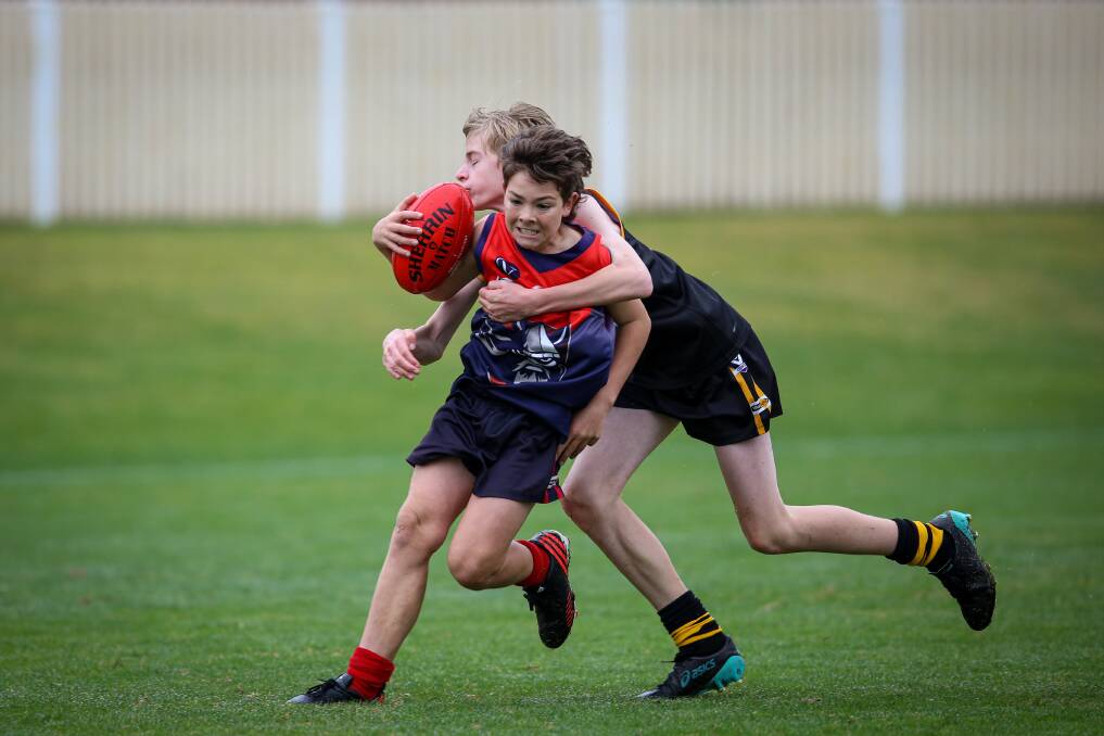 WRAPPED UP: Wodonga Raiders' Taj White is Acaught by Albury's Reece Coyne in their Albury Wodonga Junior Football League under-14s clash on Sunday. Picture: JAMES WILTSHIRE