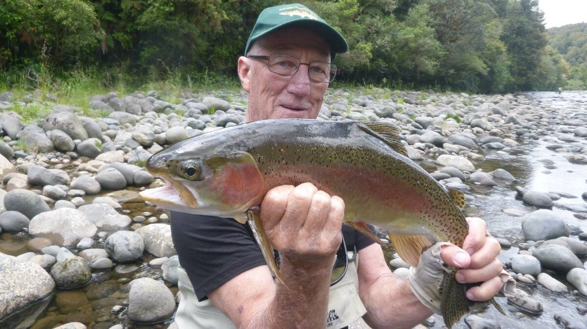 A BEAUTY: Australian Trout Foundation president Terry George with a rainbow trout near Mount Buffalo. Mr George is taking part in a fish habitat workshop at Myrtleford.