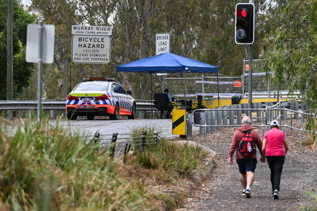 BRIDGE BETWEEN US: A couple of pedestrians make their way to the John Foord Bridge at Corowa. Communites right along the Murray River were split in two when the NSW Premier made the call to shut the state's border. Picture: MARK JESSER and JAMES WILTSHIRE