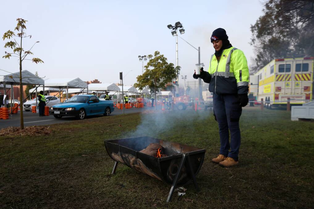 A traffic worker warms up at the Wodonga Place border checkpoint in July.