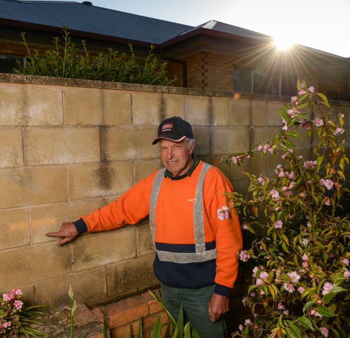 NOT SO BAD: Myrtleford resident Bob Rigoni points out the dash marking the flood heights of 2010, higher than that of last week. Mr Rigoni's property has largely been left unscathed. Picture: MARK JESSER