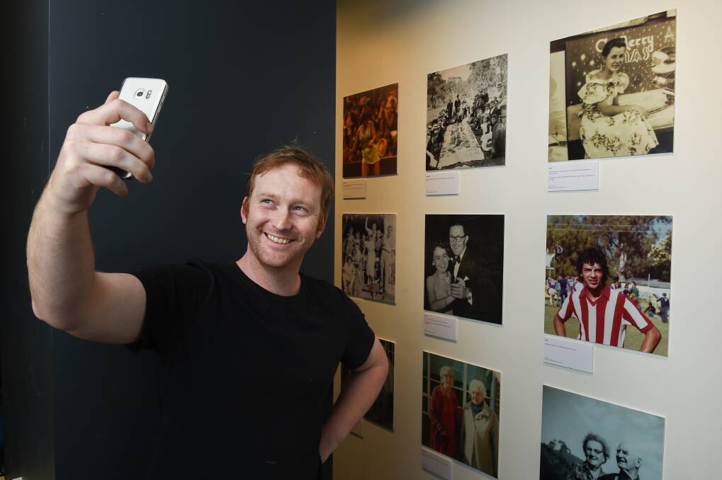 TAKE A SNAP: Albury Council exhibition co-ordinator Lance Johnson gets in the mood for Selfie, an exhibition launched last night at the Lavington Library with the Wodonga Albury Camera Club. Picture: MARK JESSER