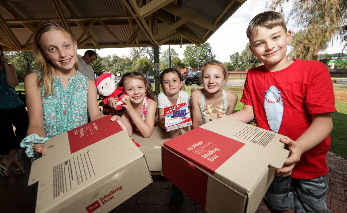 GIVING: Sacha Frichot, 8, Sophie Poulton, 6, Summer Clark, 7, Jasmine Poulton, 8, and Hamish Wallace, 8, packed Christmas gifts for soldiers. Picture: JAMES WILTSHIRE