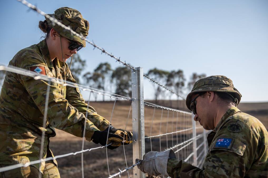 Australian Army Private Rachelle Kiver from the 7th Combat Service Support Battalion and Private Ahmadshah Taniwal from 5th/6th Royal Victoria Regiment complete the final touches on fencing outside of Corryong in January. Picture: JONATHAN GOEDHART/DEFENCE MEDIA