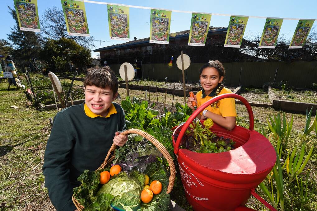 GREEN THEME: Wodonga West Primary students Travis Lewis-Anstis, 11, year 6 and Sharnaea Hall-Bidois, 10, year 4, get in the theme for Australia Post's Stamp Collecting Month, 'In the Garden'. Picture: MARK JESSER