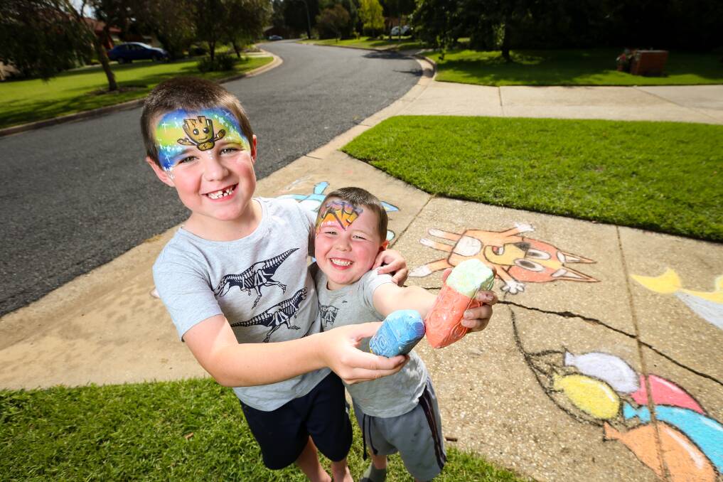 CREATIVE: Declan Killalea, 7, and Ethan, 3, spent Wednesday drawing Bluey characters with mum outside their home. Picture: JAMES WILTSHIRE