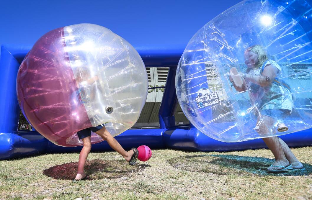 BURST OF FUN: Jordan and Abagale Rose, both 10, try out Bubble Soccer, one of the new kids' attractions brought in to draw interest from new and old revellers.