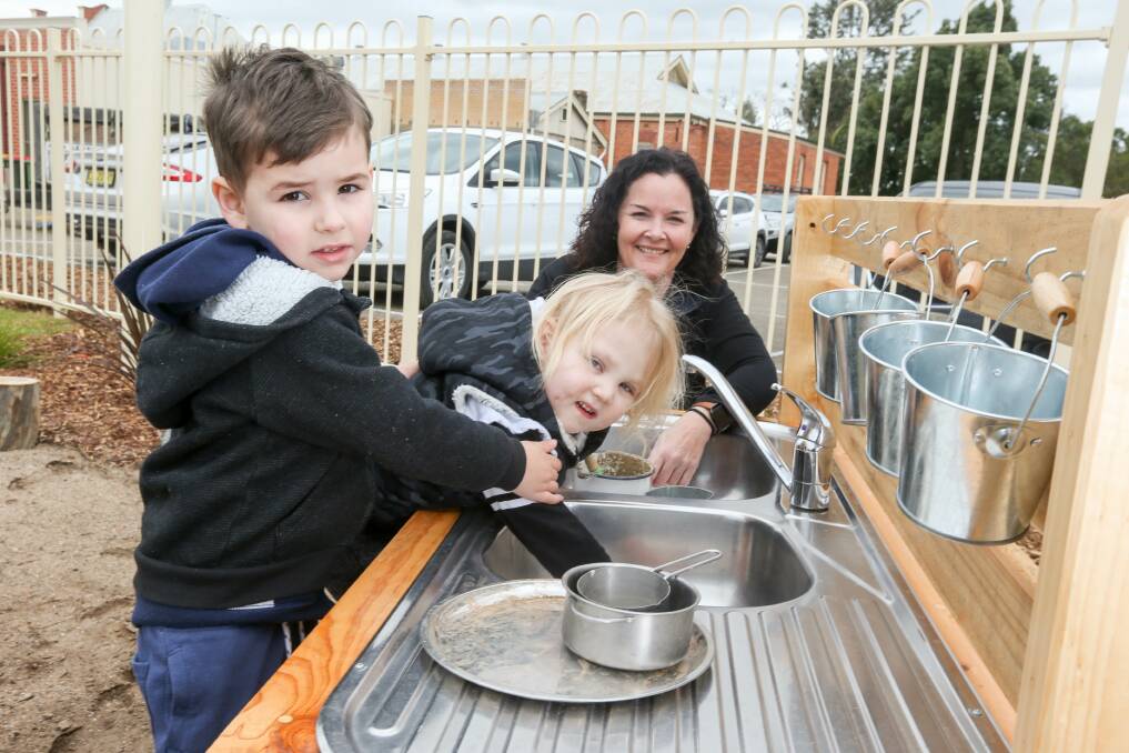 CREATE: Ryder Brincat, 4, and Ace Beardsworth, 3, with Renee Dowd in the 'mud kitchen'. The centre is fitted out with natural play equipment done by Chiltern's Palletique.