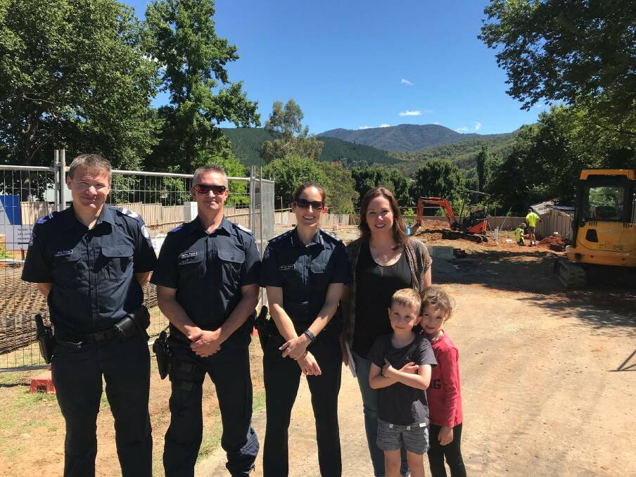 Police officers Tony Finlaw, Damien Peppler and Kerrie Hicks with Jacyln Symes and her children Archie and Pip, standing at the construction sight in Bright in January.
