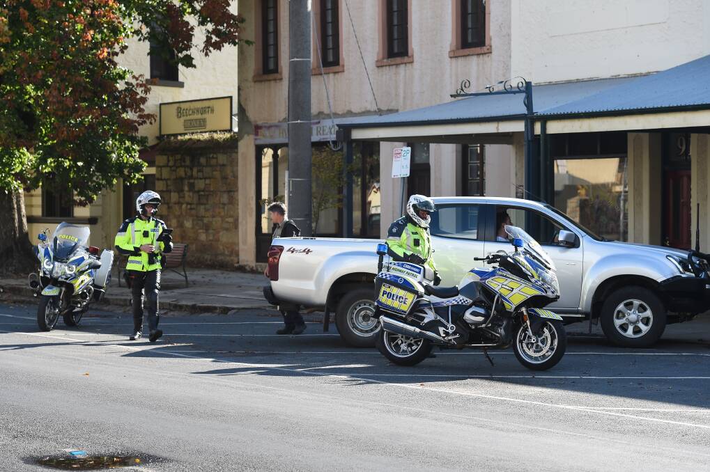 Ross Gordon from Stanley speaks to Victorian state highway patrol officers in Beechworth on Friday. Picture: MARK JESSER