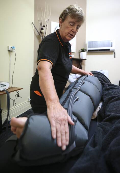 SLOW PROCESS: Lymphoedema therapist Sue Butcher treats Craig O'Grady's leg with a Medi-Rent pump.