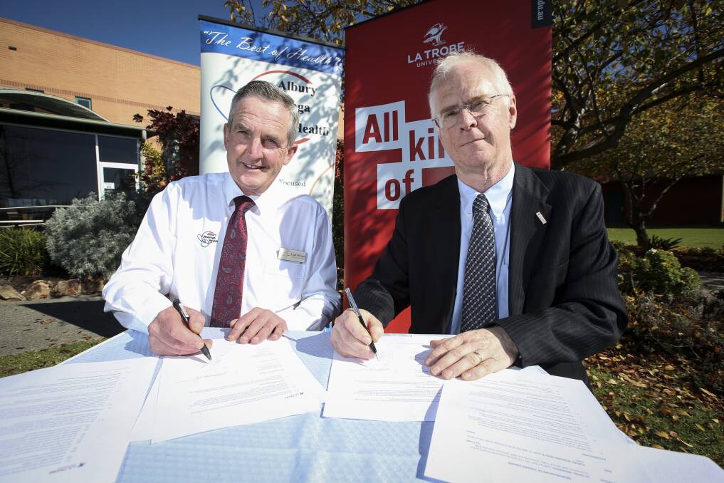 LINK: AWH chief executive Leigh McJames and La Trobe University Deputy Vice-Chancellor Keith Nugent sign an MOU. Picture: JAMES WILTSHIRE