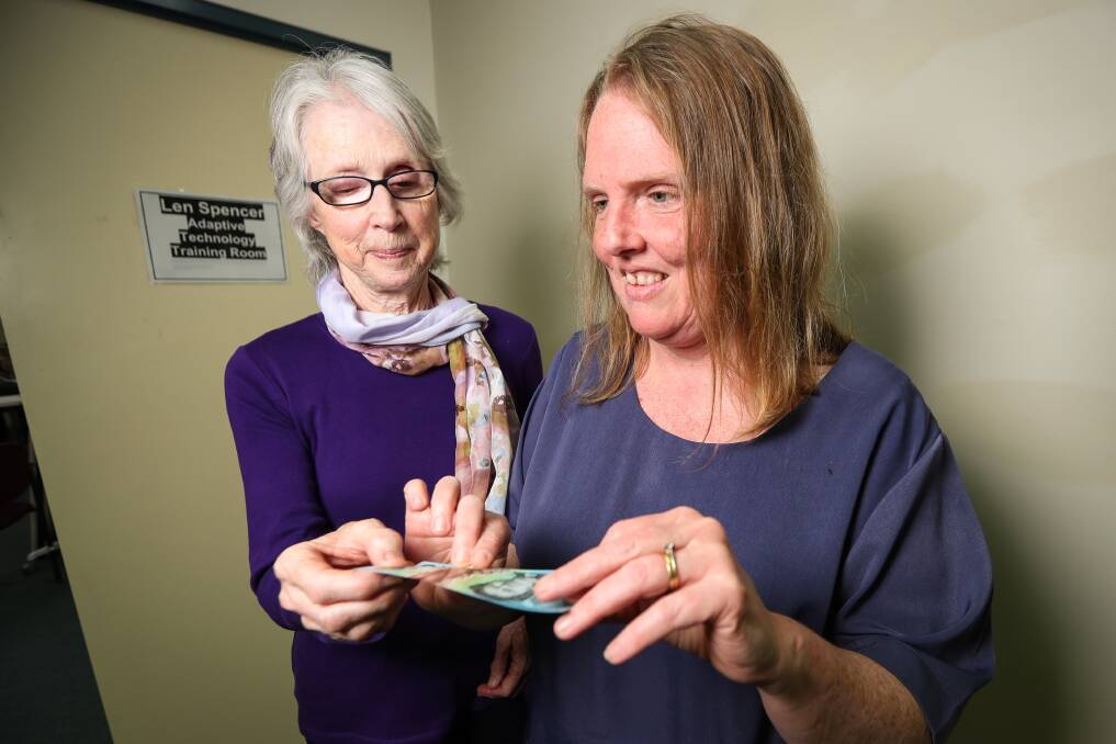 HELPFUL: Vision Australia Albury client group members Jeanette Newman and Cheryl Newman look at the new $10 note, which has a tactile feature. Picture: JAMES WILTSHIRE