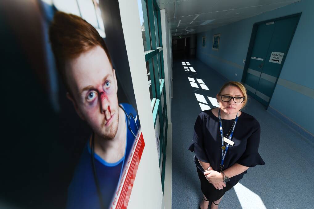 NOT OK: AWH director of people, workforce and support Virginia Boyd, with one of the posters at Albury hospital warning against occupational violence, says there are strategies in place to address bullying. Picture: MARK JESSER