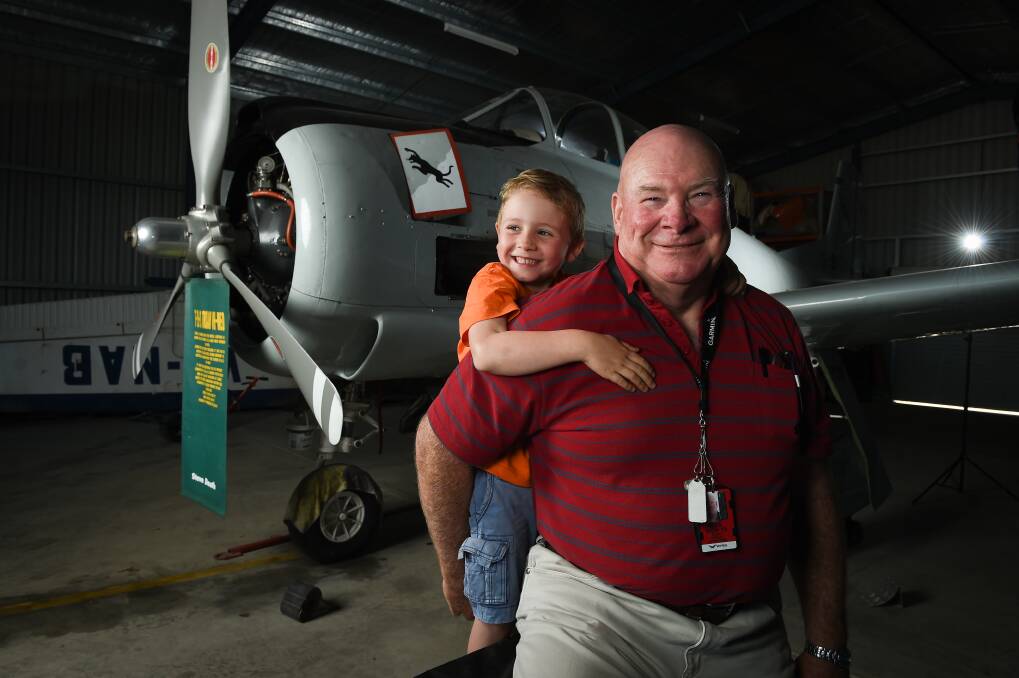 DISPLAY: Albury and District Aero Club's Steve Drage and grandson James Drage, 5, look at a T-28 Trojan war plane. Picture: MARK JESSER
