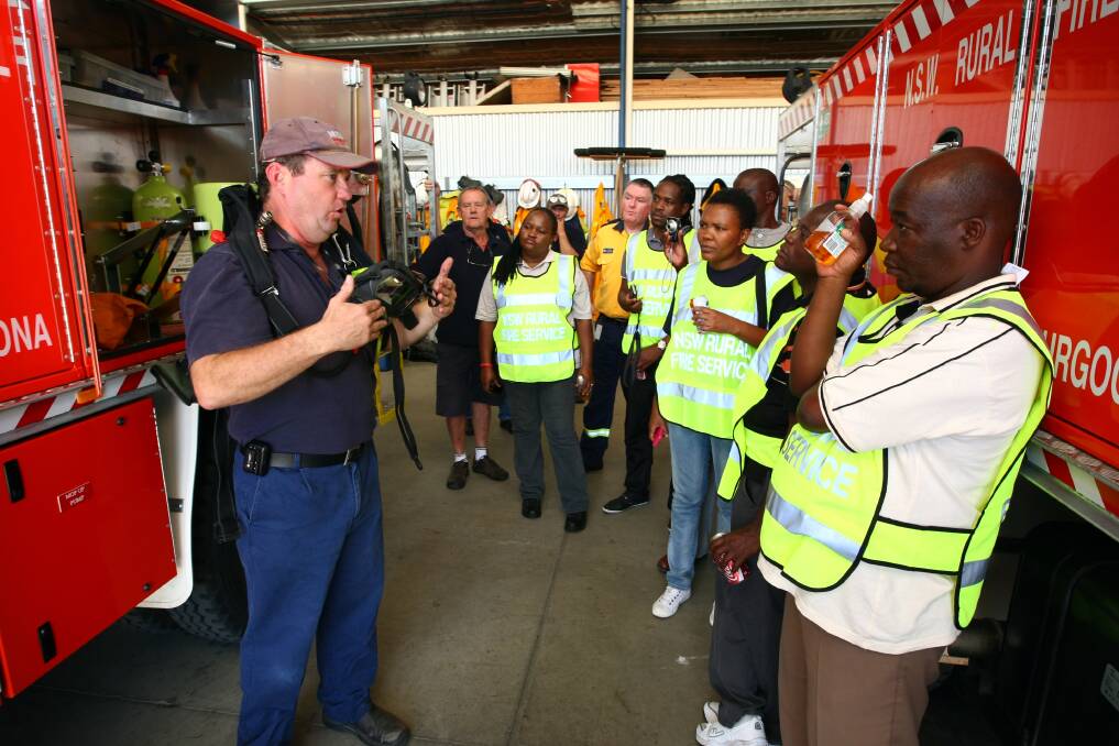Darren Gugger gives a demonstration of the Thurgoona RFS brigade's equipment to a team of firefighters from Botswana in 2013.