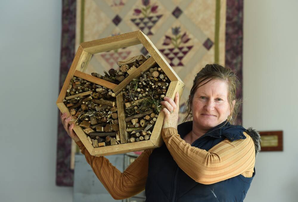 NEW SKILLS: Lorraine Ahearn shows off a bee house she made during a new woodwork course for women at Birallee Park Neighbourhood House, which held its open day. Other courses include art and first aid. Picture: MARK JESSER