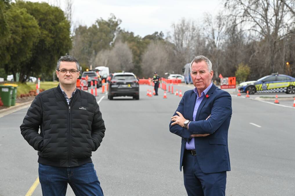 HERE AGAIN: Twin city mayors Kevin Poulton and Kevin Mack with police checking NSW drivers in the background. Picture: MARK JESSER