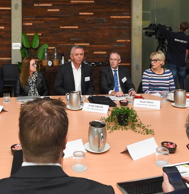 BELOW: Stuart Baker, sitting left of former Wodonga mayor Anna Speedie at a health round-table in 2019, says the "proof will be in the pudding" of the Royal Commission into Mental Health.