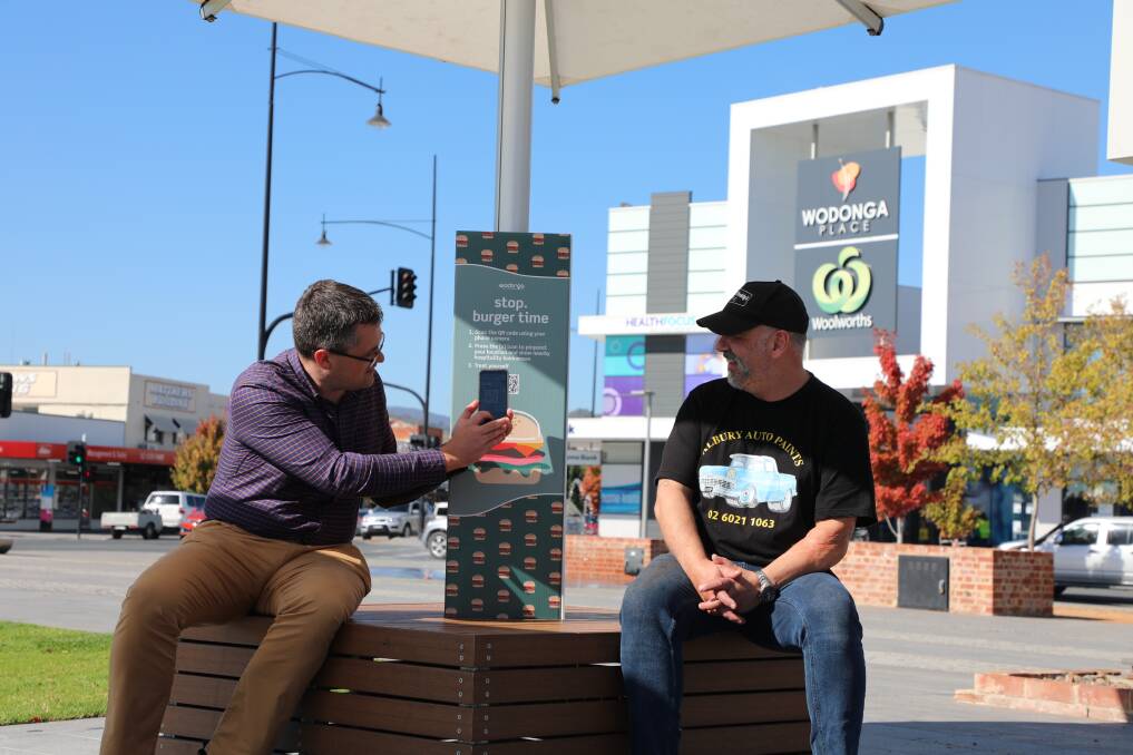 Wodonga mayor Kevin Poulton and Blind Freddy's Cafe owner John Miseski try out the QR Codes. 