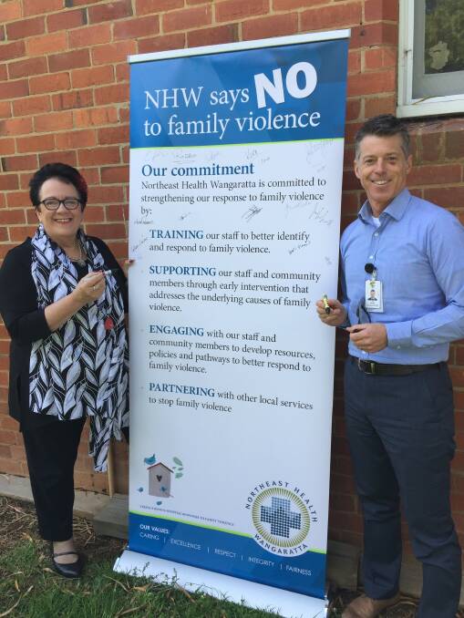 Northeast Health Wangaratta chief executive Margaret Bennett and director of community health, partnerships and well ageing, David Kidd, signing the NHW commitment against family violence

 