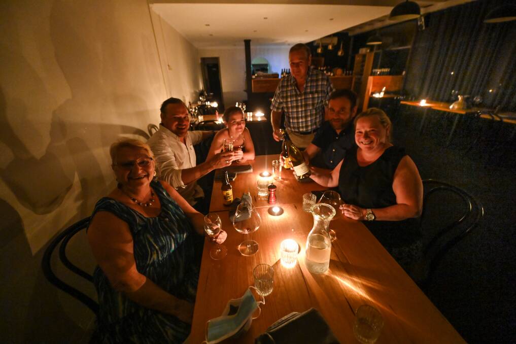 IN DARK: Maggie McDonald, Matty McDonald, Michelle McDonald, Phil McDonald, Tony Coyle and Belinda McDonald finished their meal under candlelight at Bistro Selle after the power went out in the CBD. Picture: MARK JESSER