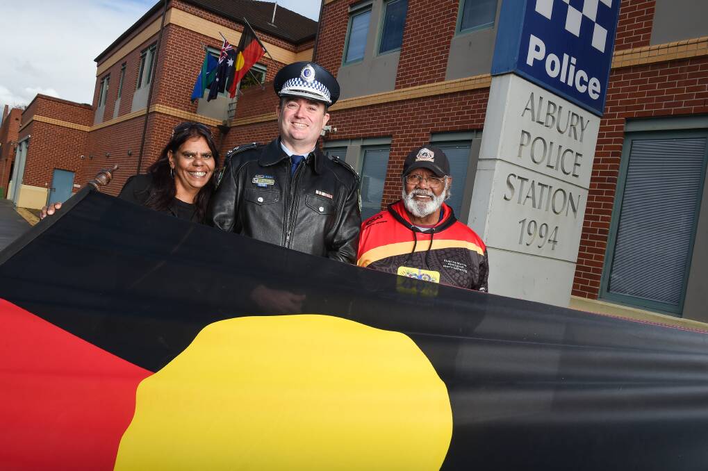 Rosina Galbraith, Superintendent Evan Quarmby and Tunney Murray celebrate new Aboriginal and Torres Strait Islander flags, permanently being flown at the Albury police station for the first time. Picture: MARK JESSER