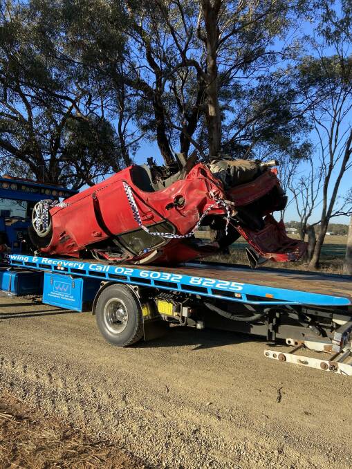 The driver of this red Commodore was taken to a Canberra hospital after a crash early on Sunday.