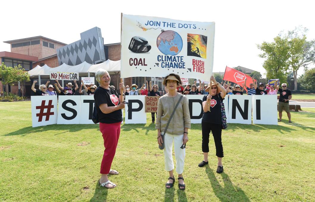 Liz Hammond of Albury and Julie Summons of Albury hold the banner made by Alison Veld for the big letters walk by Stop Adani Albury-Wodonga. Picture: MARK JESSER