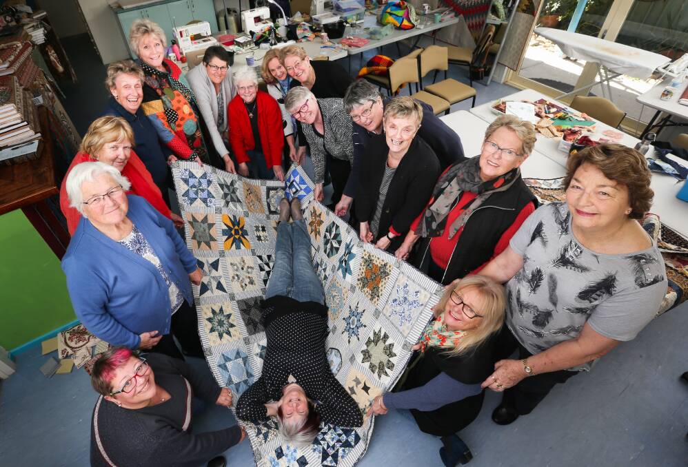 ON SHOW: Skellywag Sewing School founder Shelley Kelly closely inspects one of the quilts produced by her students, which will be raffled off at their exhibition. It runs from Friday to Sunday in Barnawartha. Picture: KYLIE ESLER