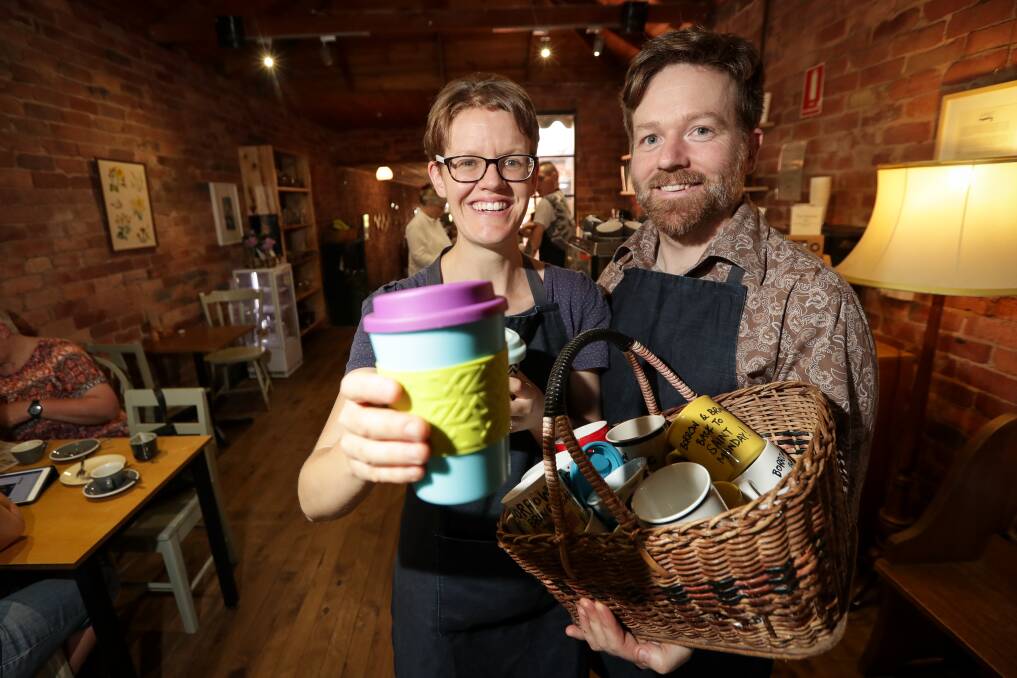 GREEN WAY: Lauren Salathiel and Chris McGorlick with Saint Monday's 'mug library'. The Yackandandah cafe has phased out single-use coffee cups in a bid to have a no-waste operation. Picture: JAMES WILTSHIRE