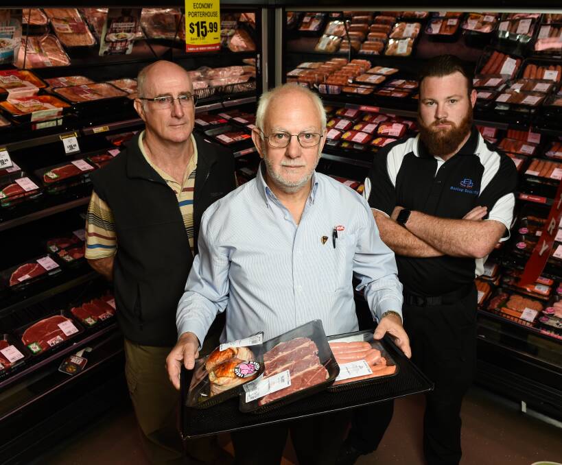 TAKING ACTION: Anthony Foley of St Vincent de Paul Society, Springdale Heights IGA owner Bob Mathews and security guard Todd Wapling aim to reduce theft with security and support for those in need. Picture: MARK JESSER