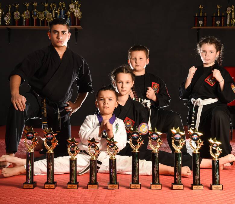 WINNERS: KMA Martial Art Albury owner Ozkan Ismail, 16, and his students Roman Ilievski, 5, Elabree Fenech, 10, Nate Fenech, 6, and Amelia Fenech, 11, won 12 trophies in a ISKA competition. Picture: MARK JESSER