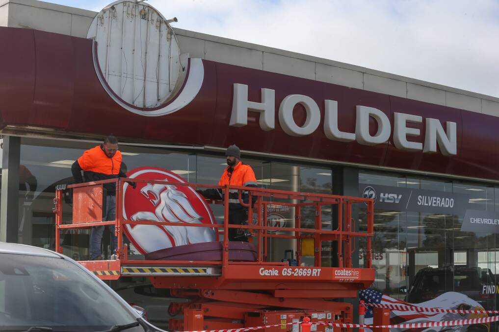 Contractors remove the Holden signage at McRae Motors Wodonga. Picture: TARA TREWHELLA